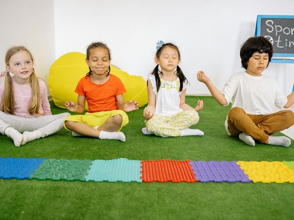 A diverse group of kids laughing during a yoga class.